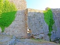 The ruins of an ancient fortress. old thick stone walls of a European fortress overgrown with greenery in the mountains. Doors and Royalty Free Stock Photo