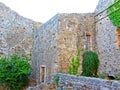 The ruins of an ancient fortress. old thick stone walls of a European fortress overgrown with greenery in the mountains. Doors and Royalty Free Stock Photo