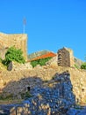 The ruins of an ancient fortress. old thick stone walls of a European fortress overgrown with greenery in the mountains. Doors and Royalty Free Stock Photo