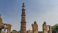 Ruins of the ancient temple complex Qutub Minar against the blue sky.