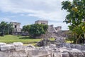 Ruins of ancient Tulum. Architecture of ancient maya. View with temple and other old buildings, houses. Blue sky and lush greenery