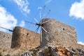 Ruins of ancient windmills on rocky mountains with blue cloudy sky