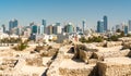 Ruins of Bahrain Fort with skyline of Manama. A UNESCO World Heritage Site