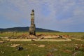 The ruins of barn tall Russian brick oven after fire stands alone in green grassy field. Burnt oven with black pipe after fire