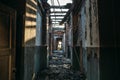 Ruins of burned brick house after fire disaster accident. Corridor inside, building without roof, heaps of ashes Royalty Free Stock Photo