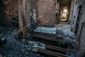 Ruins of burned brick house after fire disaster accident. Heaps of ash and arson, burnt furniture, broken windows