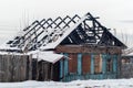 Ruins of a burnt log hut in a winter landscape