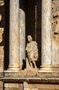 Ruins of classical statue with toga and Greek and Roman columns of the Roman Theater of Merida in Extremadura, illuminated by the Royalty Free Stock Photo