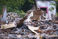 Ruins of a destroyed wooden house. Fragments of walls, boards, interior details. Summer sunny day.