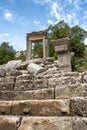 The ruins of Hadrian Gate in the ancient city of Termessos, framed by trees and a rocky foreground Royalty Free Stock Photo