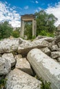 The ruins of Hadrian Gate in the ancient city of Termessos, framed by trees and a rocky foreground Royalty Free Stock Photo