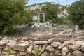 The ruins of Hadrian Gate in the ancient city of Termessos, framed by trees and a rocky foreground Royalty Free Stock Photo