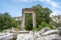 The ruins of Hadrian Gate in the ancient city of Termessos, framed by trees and a rocky foreground Royalty Free Stock Photo