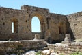 Ruins of Loarre Castle made of small stones with semicircular window parts under a blue sky