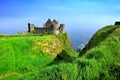 Ruins of the medieval Dunluce Castle along green cliffs, Causeway Coast, Northern Ireland