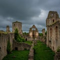 Ruins of a medieval stone structure under a cloudy sky. Features include robust walls, Royalty Free Stock Photo
