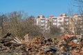 Ruins of old buildings, piles of red brick, cement, planks and metal on background of trees and new buildings in distance. Royalty Free Stock Photo