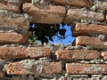 Ruins of an old fortress, a hole in the stone. Hole in the ancient fortress wall. Brick structure with a through hole Royalty Free Stock Photo