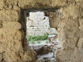 Ruins of an old fortress, a hole in the stone. Hole in the ancient fortress wall. Brick structure with a through hole Royalty Free Stock Photo