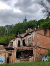 The ruins of an old house in the foreground, behind it a forest and the domes of a church