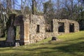 Ruins of an old industrial stone and brick building overgrown with ivy on a green hillside Royalty Free Stock Photo