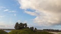 Ruins of an old stone castle on a grassy hill in front of a large river. Clonmacnoise Abbey in Ireland facing the Shannon River Royalty Free Stock Photo