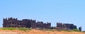 Remains of Palace - Panoramic View of Historic Old Ruined Castle with Sand, Green Grass, and Blue Sky - Chorwad, Gujarat, India Royalty Free Stock Photo