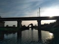 the ruins of the pillars of the old bridge next to the bridge over Volkhov at sunset