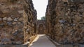 Ruins of the Qutub Minar temple complex. A narrow passage between two weathered, dilapidated stone walls Royalty Free Stock Photo