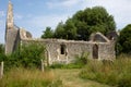 Ruins of roofless church in overgrown grave yard on summer day Royalty Free Stock Photo