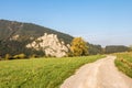 Ruins of Strecno castle in autumn landscape with dirt road
