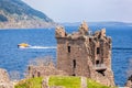 Ruins of Urquhart Castle against boat on Loch Ness in Scotland