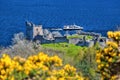 Ruins of Urquhart Castle against boat on Loch Ness in Scotland