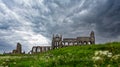 Ruins of Whitby Abbey against a dramatic black sky in Whitby, North Yorkshire, UK