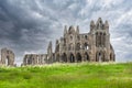 Ruins of Whitby Abbey against a dramatic black sky in Whitby, North Yorkshire, UK