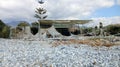 Ruins of a white building surrounded by trees and small rocks Royalty Free Stock Photo