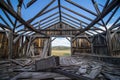 The ruins of a wooden building on the prairie, seen from the inside.