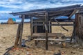 The ruins of a wooden house on the sandy beach