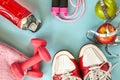 ruits, dumbbells, water bottle, rope, sneakers and meter on a blue background