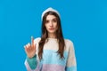Rule number one. Serious-looking assertive woman in winter sweater, hat, raising one finger in disapproval, restriction