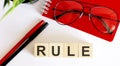 RULE Text of business office on wooden cubes in front of office desk