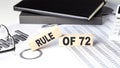 RULE OF 72 - text on a wooden block with chart and notebook