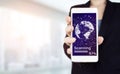 Rule the world, world domination concepts. Hand hold white smartphone with digital hologram world, earth, map, globe sign on light Royalty Free Stock Photo