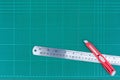A ruler and cutter on green cutting mat Royalty Free Stock Photo