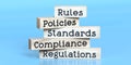 Rules, policies, standards, compliance, regulations - words on wooden blocks