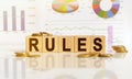 RULES the word on wooden cubes, cubes stand on a reflective surface, in the background is a business diagram Royalty Free Stock Photo