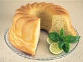Rum baba on the glass plate with lime and basil. Homemade round yeast cake Royalty Free Stock Photo