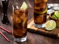 Rum and cola cocktail with lime slice in tall glasses