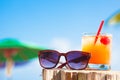 Rum punch cocktail and sunglasses at tropical