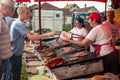 RUMA, SERBIA - JUNE 25, 2023: Crowd of people grilling meat and patties, called pljeskavica, on a market in Serbia, in a typical